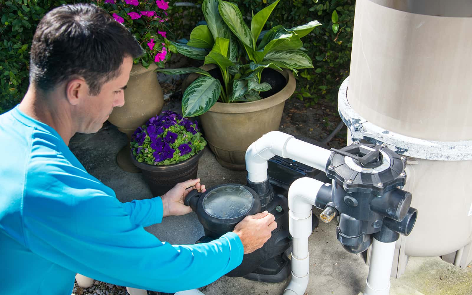 Technician inspecting pool equipment pad during a swimming pool inspection